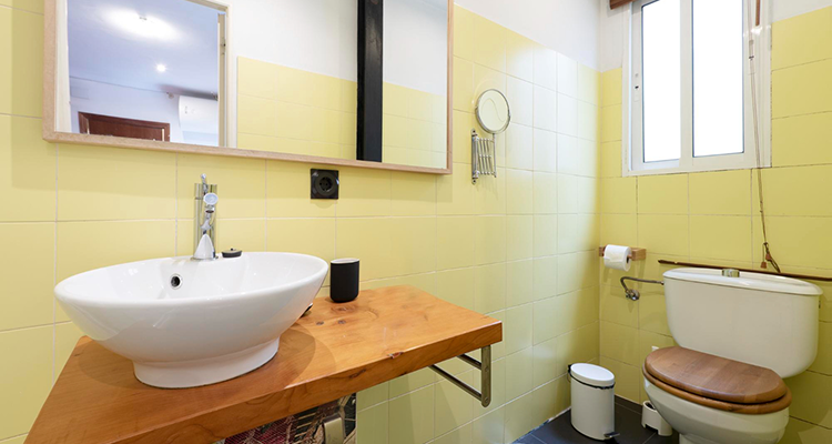 Modern bathroom with custom wooden vanity, vessel sink, bathtub and shower features